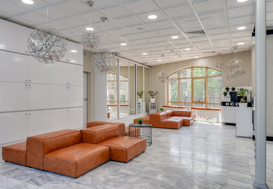 Spacious modern lounge featuring leather sofas and contemporary lighting, ideal for luxury interior design concepts.
